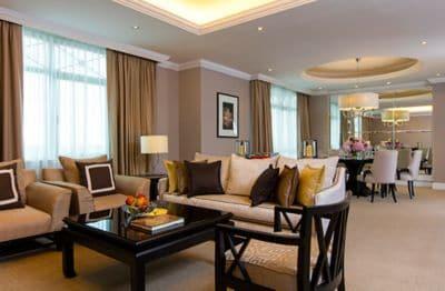 Tailored living and dining rooms in neutral hues with white crown molding and dark wood accents