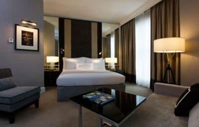 Gray walls, mirrored wall panels, sleek furnishings and floor-to-ceiling windows in a guest room