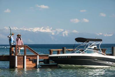 A man and a woman walk toward a boat docked at the pier
