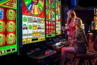 Two ladies playing slot machines at The Casino