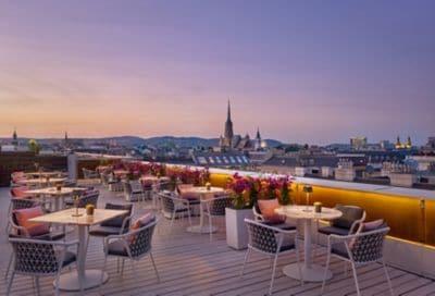 tables and chairs on a rooftop at sunset