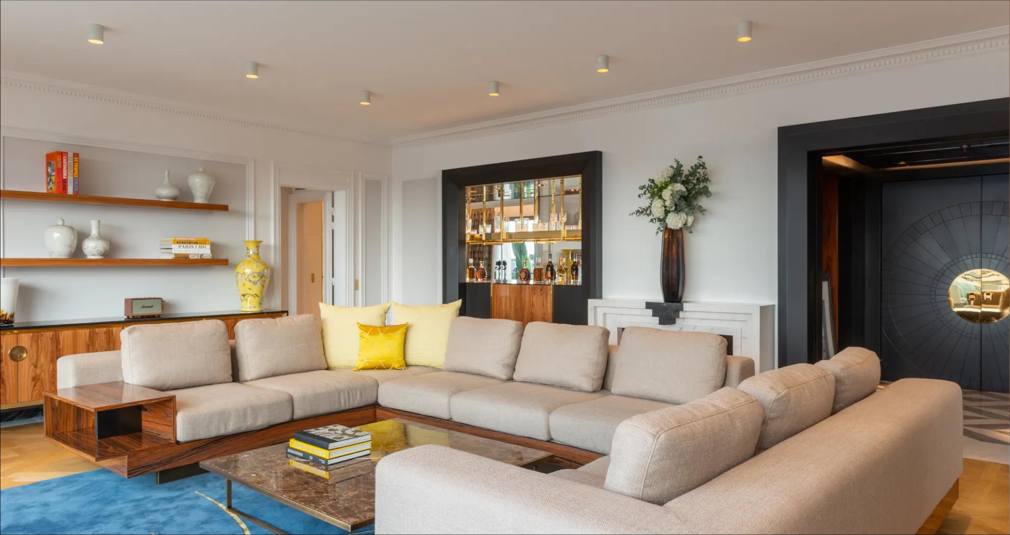Elegant living room with large windows, refined decor and cozy ambiance.