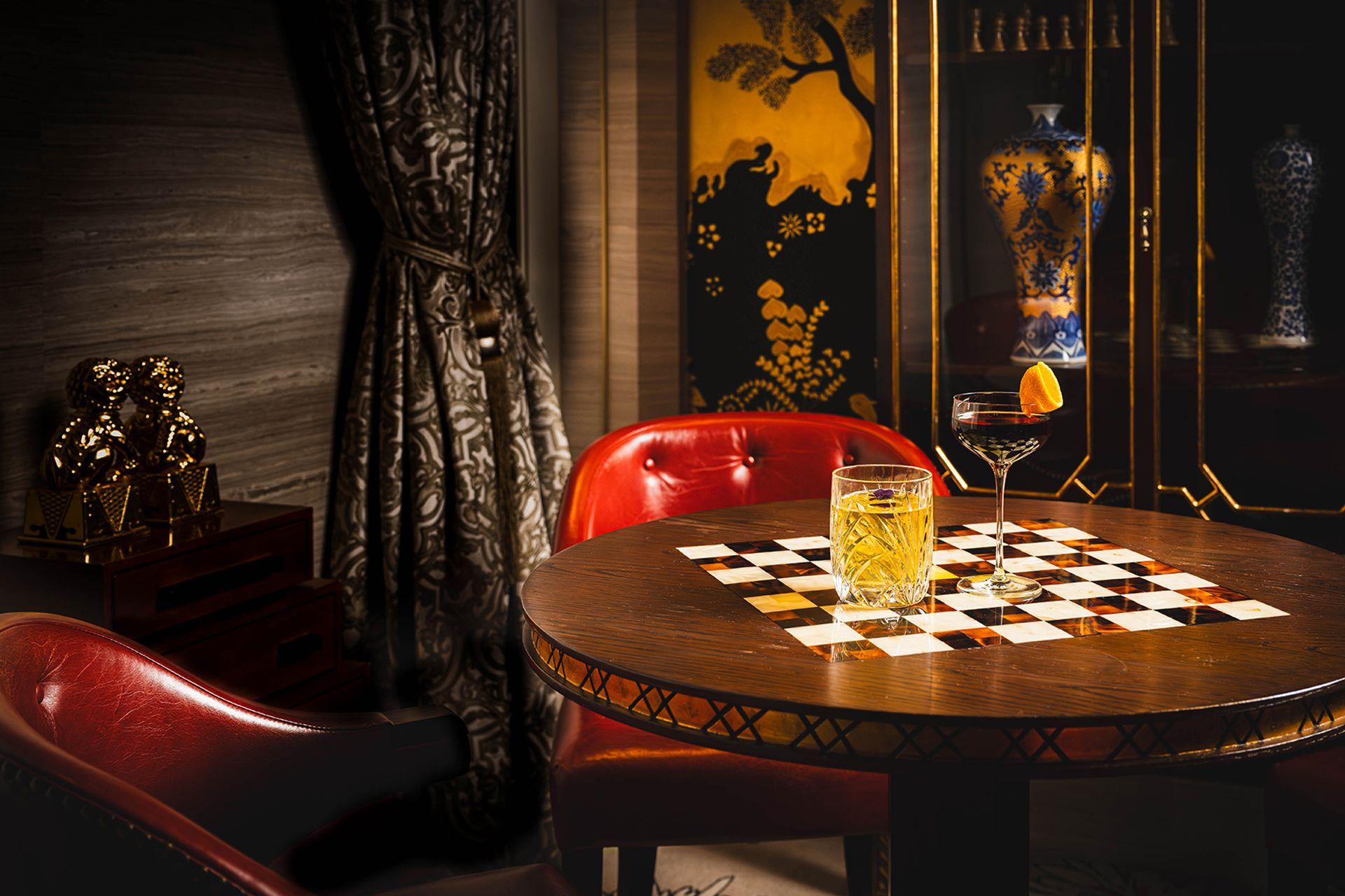 Bar Patuá blends Eastern motifs with warm lighting to create a calm and refined atmosphere. Checkerboard‑patterned round tables paired with elegant glassware set the stage for a sophisticated, story‑rich drinking experience. With red leather seating contrasted against gold and black accents, it is an ideal destination in Macau for bar lovers, hotel guests, and those seeking a classic cocktail experience.