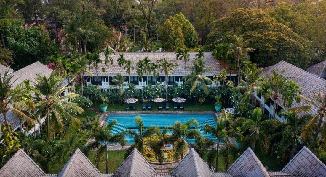 Aerial view of Shinta Mani Angkor resort with central swimming pool, tropical gardens, and surrounding guest wings.