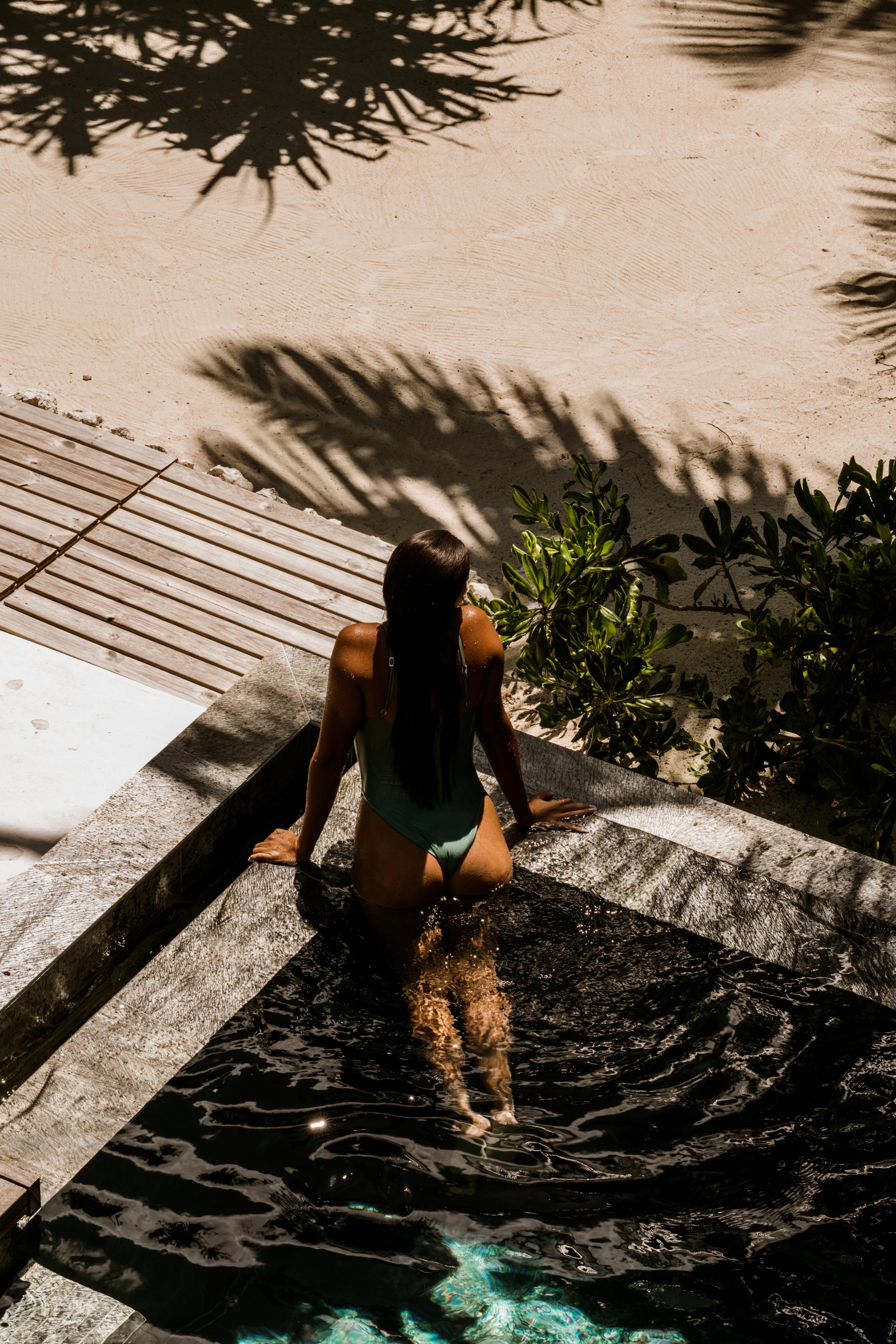 Woman emerging from a pool on the sand at our Polynesian spa